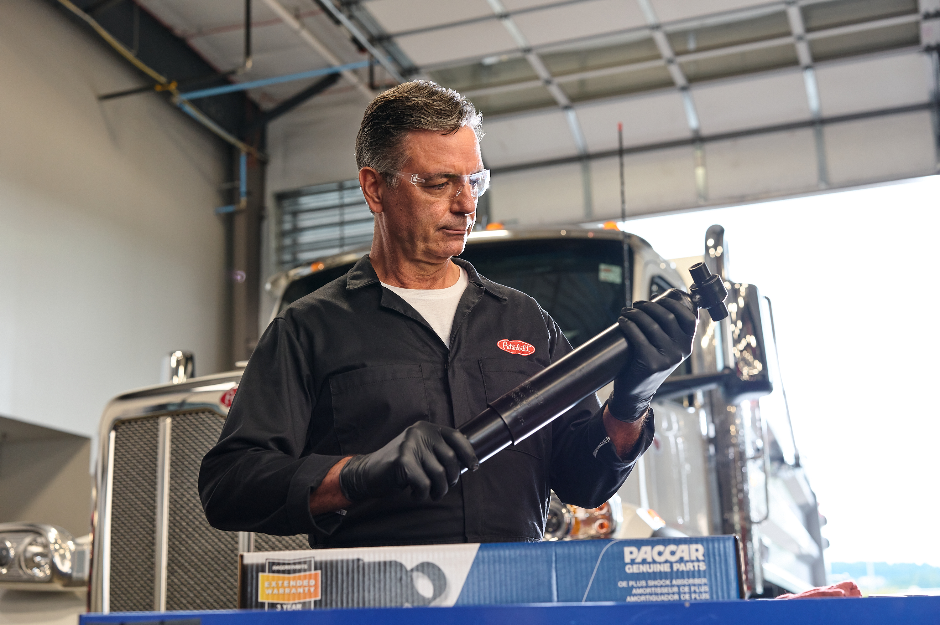 A Peterbilt technician services a truck
